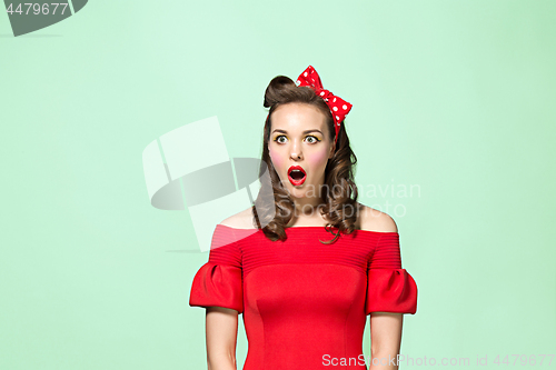 Image of Beautiful young woman with pinup make-up and hairstyle. Studio shot on white background