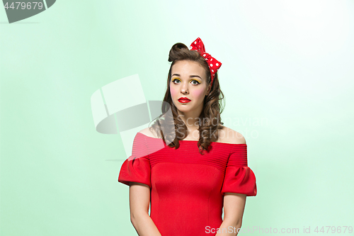 Image of Beautiful young woman with pinup make-up and hairstyle. Studio shot on white background