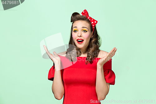 Image of Beautiful young woman with pinup make-up and hairstyle. Studio shot on white background