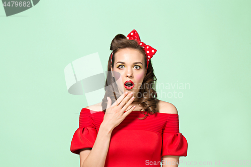 Image of Beautiful young woman with pinup make-up and hairstyle. Studio shot on white background