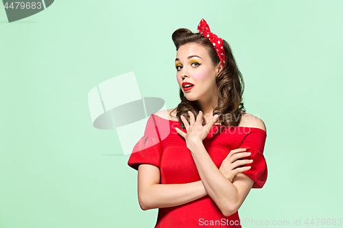 Image of Beautiful young woman with pinup make-up and hairstyle. Studio shot on white background