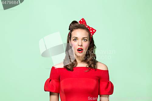 Image of Beautiful young woman with pinup make-up and hairstyle. Studio shot on white background