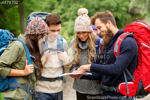 Image of friends or travelers hiking with backpacks and map