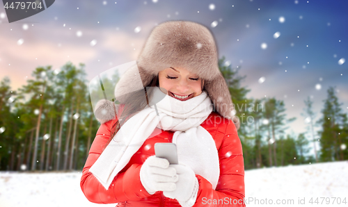 Image of happy woman with smartphone in winter