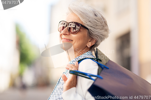 Image of senior woman in sunglasses with shopping bags