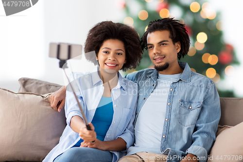 Image of couple with smartphone taking selfie on christmas