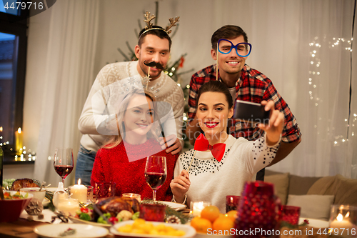 Image of friends taking selfie at christmas dinner