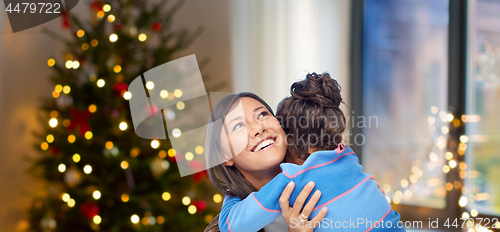 Image of happy mother hugging her daughter on christmas