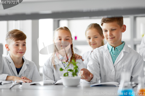 Image of kids or students with plant at biology class