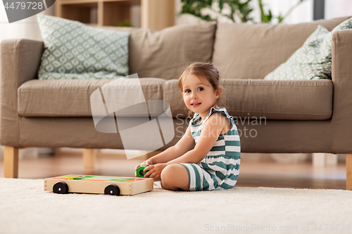 Image of happy baby girl playing with toy blocks at home