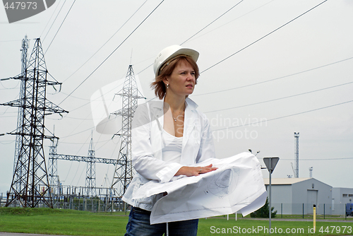 Image of Woman engineer or architect with white safety hat drawings and e