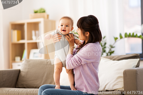 Image of happy young asian mother with little baby at home