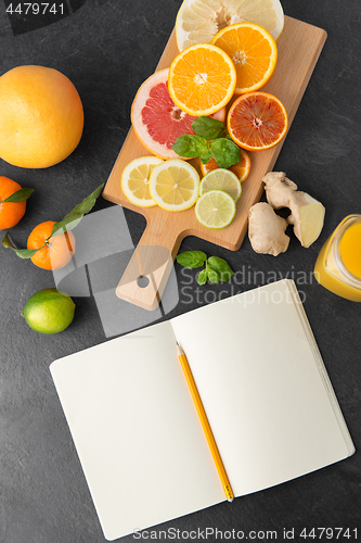 Image of close up of fruits and notebook on slate table top