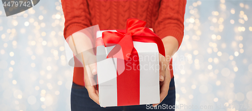 Image of close up of woman in red sweater holding gift box