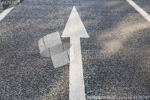 Image of close up of arrow road surface marking on asphalt