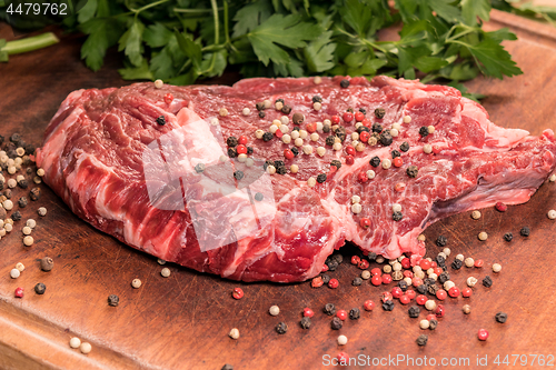 Image of steak of beef on a wooden board with spices and parsley