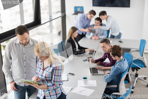 Image of Two Business People Working With Tablet in office