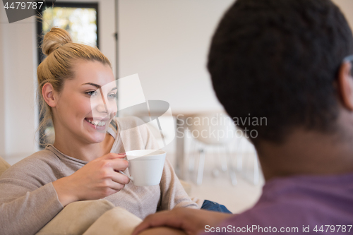 Image of Young multiethnic couple  in front of fireplace