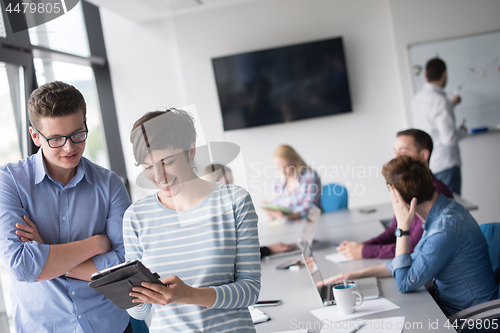 Image of Two Business People Working With Tablet in office