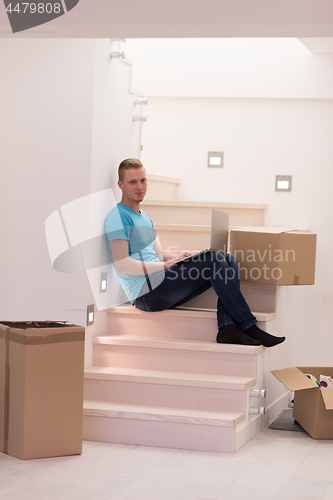 Image of young man sitting in stairway at home