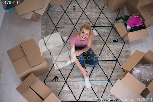 Image of top view of young beautiful woman sitting on the floor