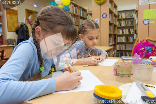 Image of Schoolgirls in extracurricular activities draw in the library