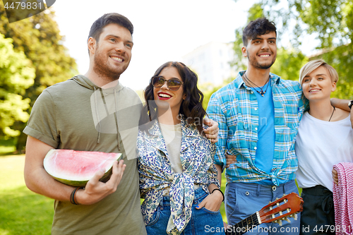 Image of friends with guitar going to picnic at park