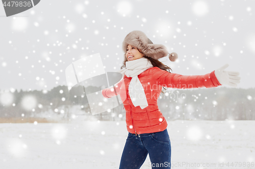 Image of happy woman in winter fur hat having fun outdoors