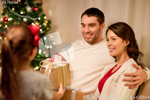 Image of happy family with christmas present at home