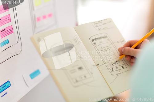 Image of ui designer with user interface sketch in notebook