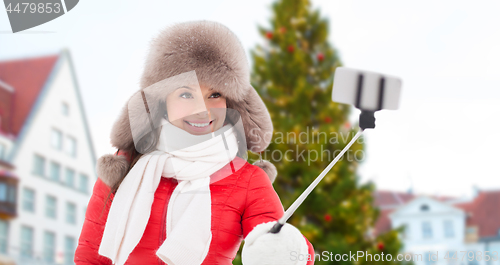 Image of woman taking selfie over christmas tree