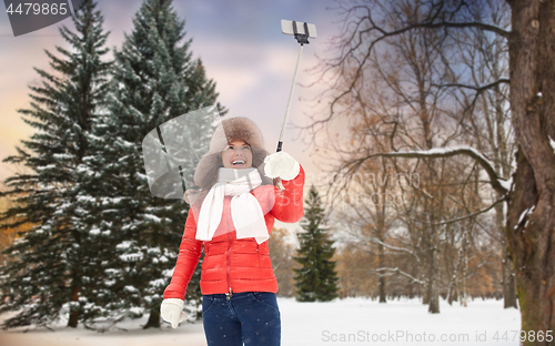 Image of happy woman taking selfie over winter forest