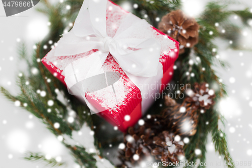 Image of close up of christmas gift and fir wreath on snow