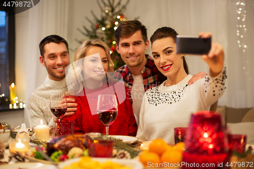 Image of friends taking selfie at christmas dinner