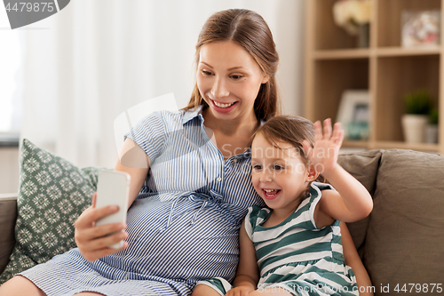 Image of pregnant mother and daughter having video chat