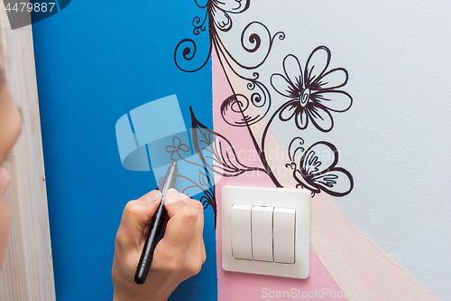 Image of The artist paints the walls of the children\'s room pattern