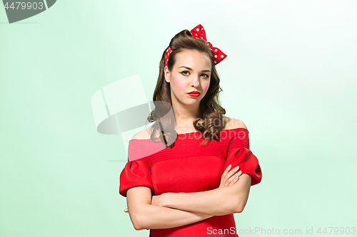 Image of Beautiful young woman with pinup make-up and hairstyle. Studio shot on white background