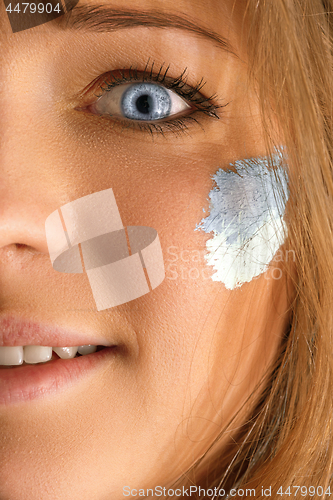 Image of Portrait of a woman with the flag of the Argentina painted on her face.