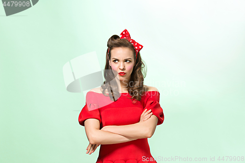 Image of Beautiful young woman with pinup make-up and hairstyle. Studio shot on white background