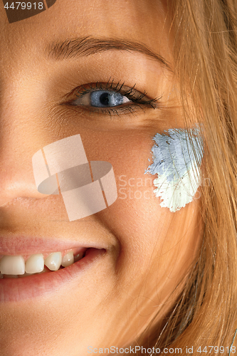 Image of Portrait of a woman with the flag of the Argentina painted on her face.