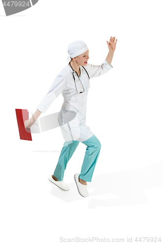 Image of Beautiful young woman in white coat running at studio. Full length studio shot isolated on white.