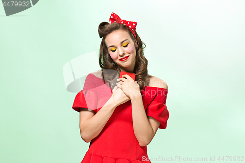 Image of Beautiful young woman with pinup make-up and hairstyle. Studio shot on white background