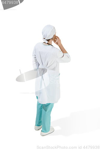 Image of Beautiful young woman in white coat posing at studio. Full length studio shot isolated on white.