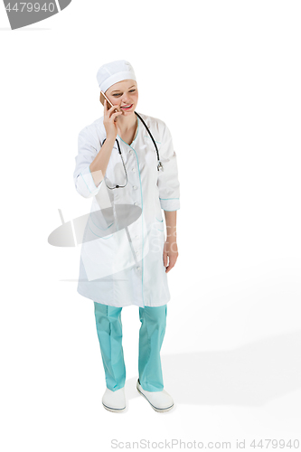 Image of Beautiful young woman in white coat posing at studio. Full length studio shot isolated on white.