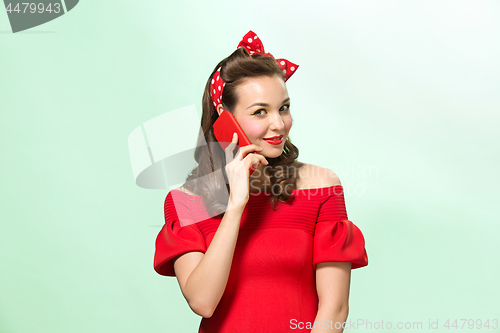 Image of Beautiful young woman with pinup make-up and hairstyle. Studio shot on white background