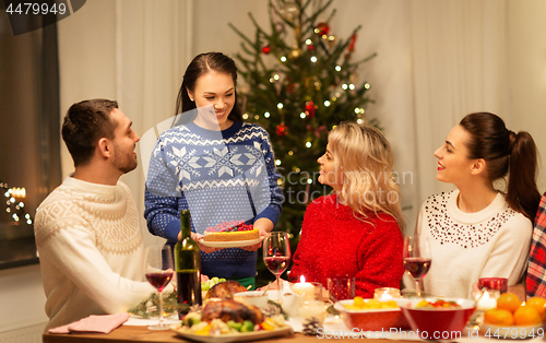 Image of happy friends having christmas dinner at home