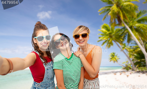 Image of happy teenage girls taking selfie over beach