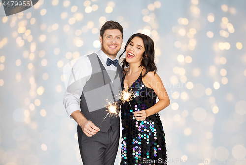 Image of happy couple with sparklers at party