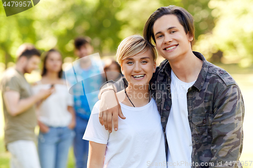 Image of happy teenage couple hugging at summer park
