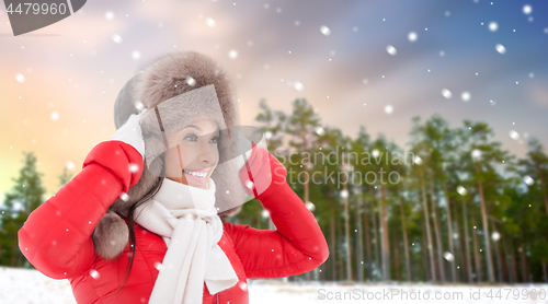 Image of happy woman in fur hat over winter forest